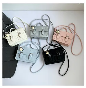 Flat lay of small crossbody bags in five colors with cute charms on white background