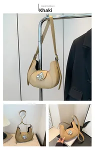 Macro detail of khaki crescent underarm bag with silver floral buckle and leather strap