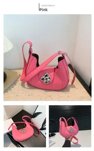 Detail view of pink half-moon underarm bag featuring a silver metal flower buckle