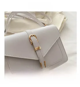 Detailed close-up of premium cream faux leather texture and polished gold buckle accents