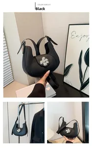 Detail of black Hobo bag featuring a silver floral buckle and adjustable strap
