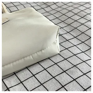 Dettaglio della trama del tessuto in nylon e delle cuciture della mini borsa beige