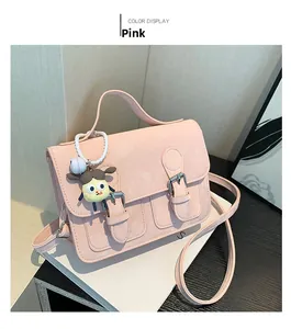 Vista dall'alto di borsa rosa a tracolla opaca con un grazioso ciondolo decorativo