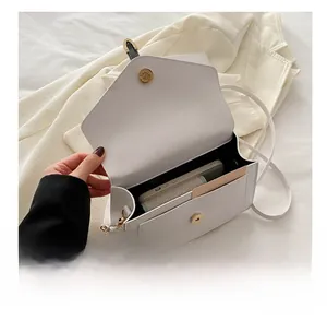 Internal view of the white crossbody bag showing storage capacity for phone and wallet