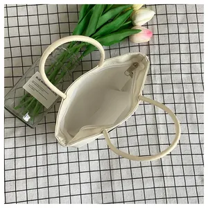 Vista dall'alto della borsa in nylon bianco crema con cerniera e spazio interno
