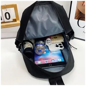 Vue de dessus d'un petit sac à bandoulière noir avec tablette et accessoires quotidiens