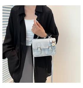 Detailed view of a silver vintage square bag with buckle straps and a cartoon charm
