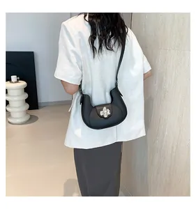 Model back view of black half-moon underarm bag with decorative metal flower buckle