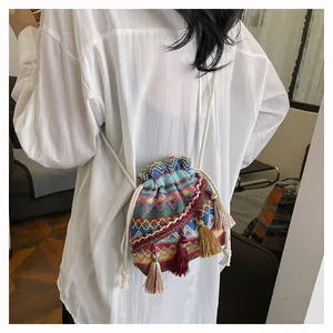 Dettaglio borsa a secchiello etnica con ricami colorati, coulisse e nappe decorative