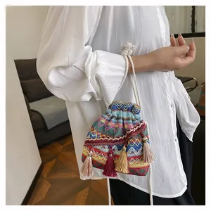 Dettaglio della borsa a secchiello boho intrecciata colorata con nappe e coulisse