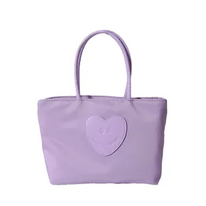 Graziosa borsa tote in nylon lavanda con toppa a cuore e doppi manici su bianco