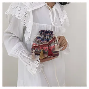 Dettaglio ravvicinato di una borsa a secchiello boho con nappe colorate e coulisse