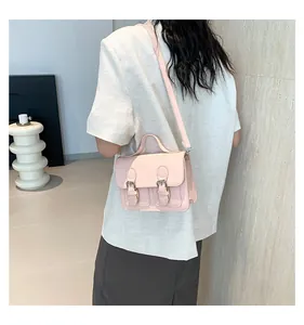 Vista posteriore della borsa vintage rosa indossata a tracolla su un blazer beige