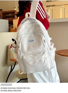 Detail of white textured backpack showing fabric pattern, side pocket, and cute dog charm