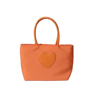 Joli sac cabas en nylon orange avec écusson en cuir en forme de cœur et anses