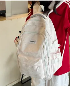 Detail of a beige backpack showing geometric wave texture and the side water bottle pocket