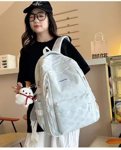 Close-up of light blue backpack with diamond weave texture and cute bunny keychain