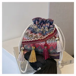 Dettaglio della borsa a secchiello tessuta con lunghe nappe colorate e motivi etnici
