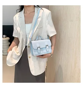 Dettaglio della borsa vintage in pelle azzurra con cinturini paralleli e fibbie in metallo