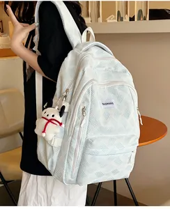 Close-up of light blue wavy textured backpack with multi-zipper and cute puppy charm