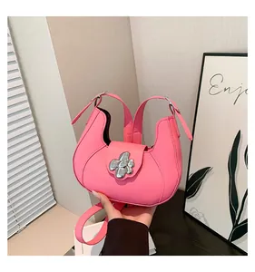 Detail of light pink shoulder bag with silver flower buckle and smooth leather finish