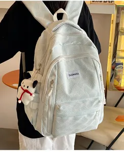 Detail of light blue backpack with unique 3D woven texture and cute white puppy plush charm