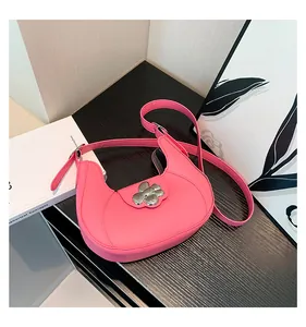 Detail of pink faux leather crescent underarm bag with silver flower buckle clasp