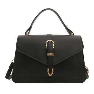 Classic black matte leather crossbody bag with top handle and gold buckle detail