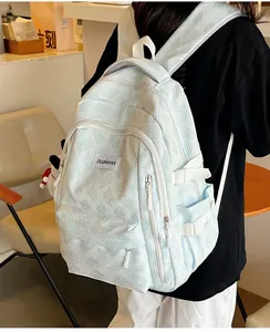 Lifestyle shot of a light blue large capacity backpack in a cozy cafe setting
