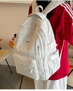 Detailed view of white backpack featuring geometric texture and functional side pockets