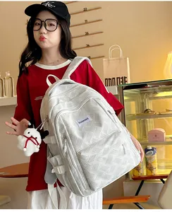 Detailed texture of white geometric woven backpack with a cute plush dog keychain accessory
