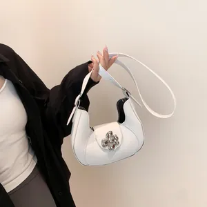 White crescent underarm bag with large silver metallic flower buckle and adjustable strap