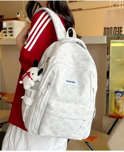 Detailed side view of white woven texture backpack with cute plush puppy charm