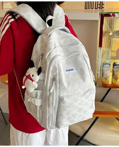 Detail of white textured backpack with waffle weave fabric and cute puppy keychain