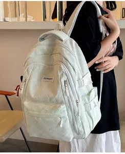 Detail of mint green backpack featuring textured fabric and DUOMANX brand label