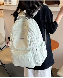 Detail view of mint green backpack with geometric embossed texture and side buckle straps
