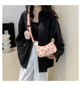 Detalle del bolso de pana rosa con estampado de fresas y pequeño monedero redondo
