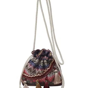 Borsa a secchiello in stile etnico intrecciata con motivi geometrici e nappe