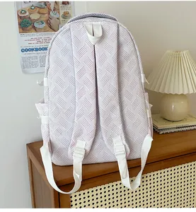 Detail of light purple backpack showing geometric textured fabric and side storage pocket