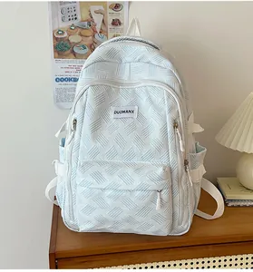 Close-up of geometric woven texture and branded label on light blue school backpack