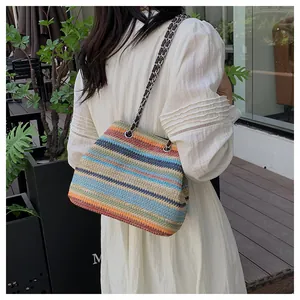 Détail d'un sac en paille arc-en-ciel avec bandoulière en chaîne et texture tissée été
