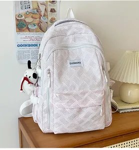 Detail of white woven lattice texture backpack with a cute dog plush charm and logo