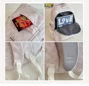 Detail view of pink backpack with geometric texture, breathable straps, and spacious interior