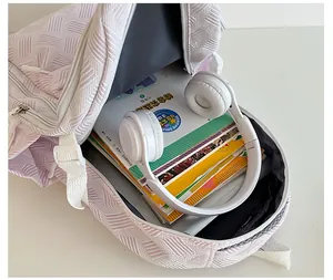 Top view of open lavender backpack showing large interior storage for books and headphones