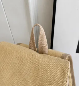 Close-up of durable woven handle and sturdy canvas texture on the khaki bucket backpack