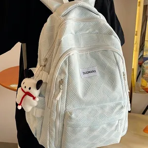 Light blue textured backpack with cute plush charm and spacious multi-pocket design