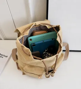 Interior view showing the large capacity of the beige canvas bucket backpack