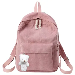 Pink corduroy backpack detail showing texture with cute plush bear charm hanging on side