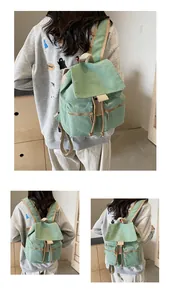 Vista detallada de la mochila de lona con cordón, ribetes en contraste y bolsillos con cremallera