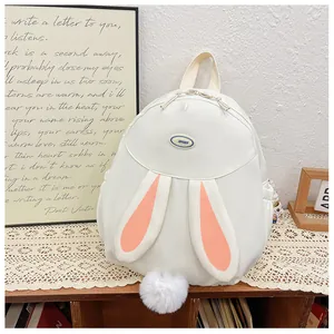 Detalle de mochila de conejo blanco con orejas de felpa y pompón blanco decorativo